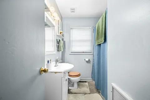 a bathroom with a sink toilet and a mirror