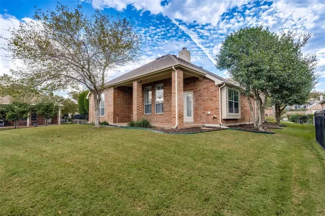 a front view of a house with a garden and trees