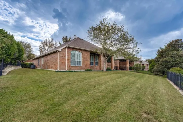 a view of a yard in front of a house with a large tree