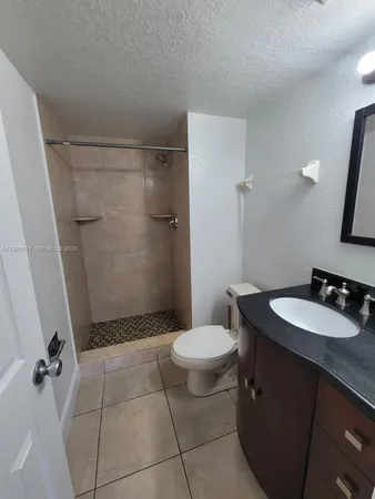 a bathroom with a granite countertop sink toilet and shower
