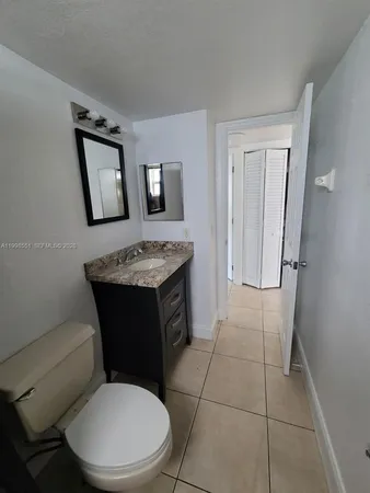 a bathroom with a toilet a sink and mirror
