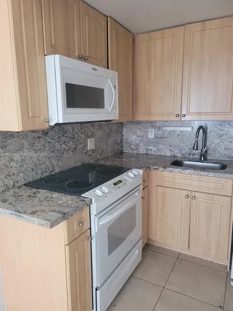 a kitchen with granite countertop white cabinets and stainless steel appliances