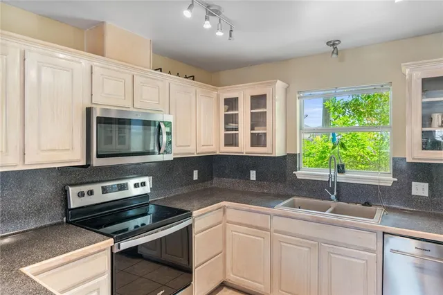 a kitchen with a sink stove and microwave