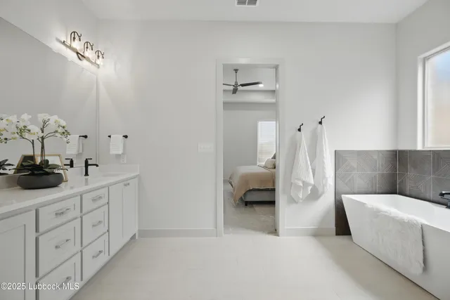 a en suite bathroom with a tub sink and view bedroom