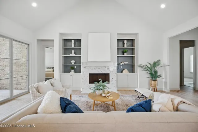 a living room with furniture fireplace and a large window
