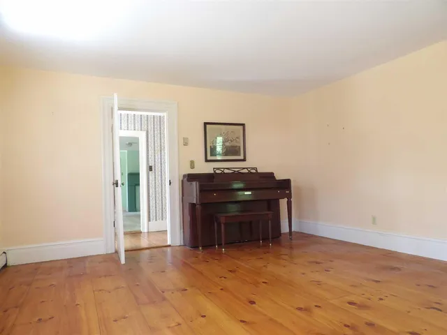 a view of empty room with wooden floor and cabinets