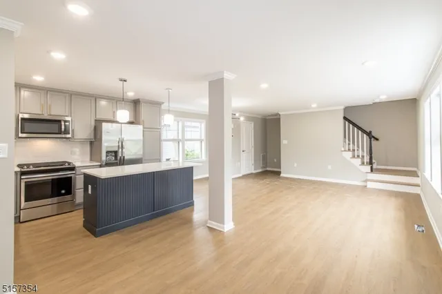 a view of kitchen with kitchen island and stainless steel appliances