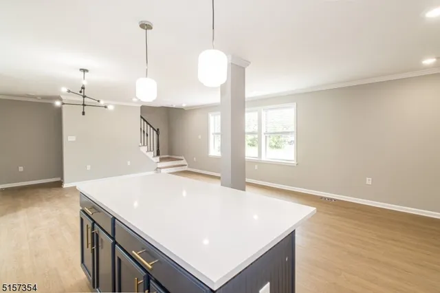 a kitchen with kitchen island a counter space a sink appliances and cabinets