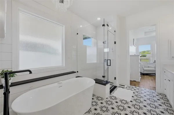 a bathroom with a tub sink and mirror