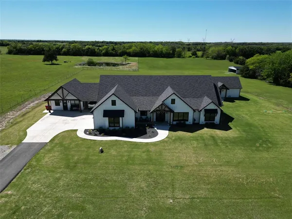an aerial view of a house with a big yard