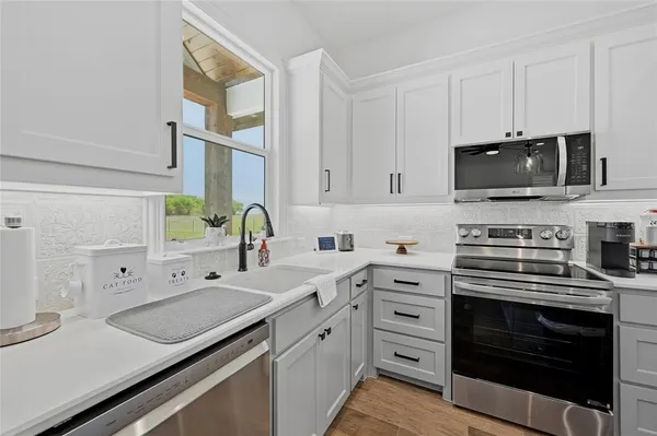 a kitchen with a sink stove and microwave