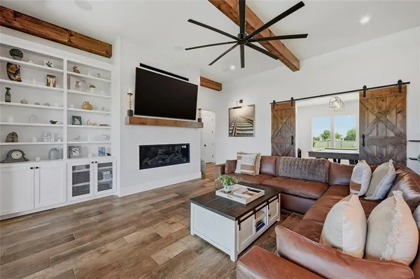 a living room with furniture a flat screen tv and a fireplace