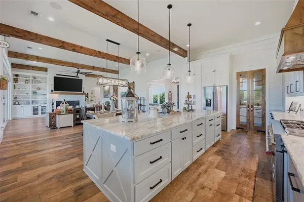 a large white kitchen with a large window a sink and a refrigerator