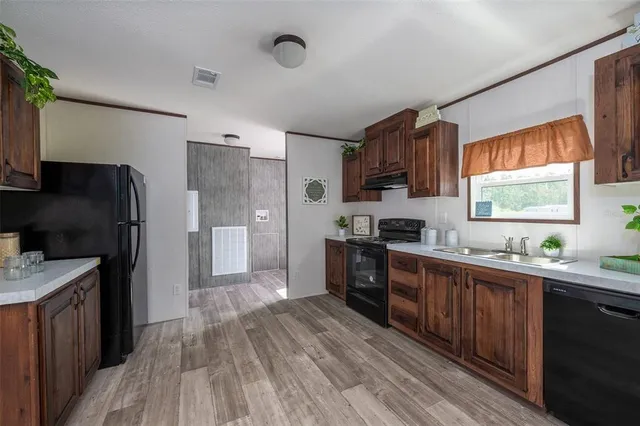 a kitchen with granite countertop a refrigerator stove top oven and sink