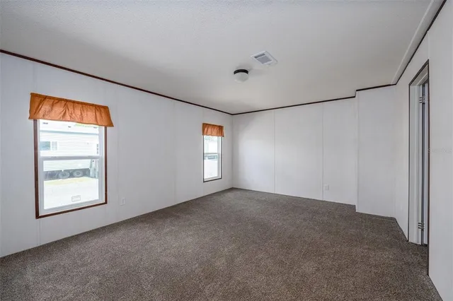 an empty room with windows and closet