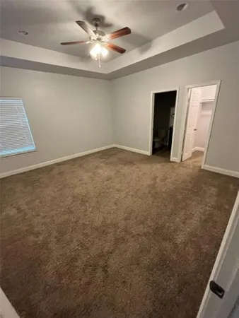 en empty room with windows and ceiling fan