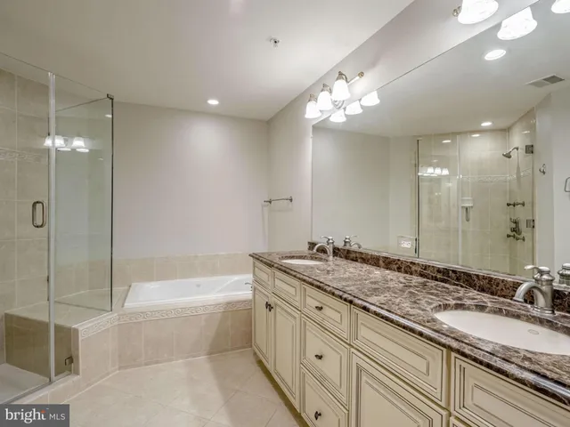 a bathroom with a granite countertop sink a large mirror and a bathtub