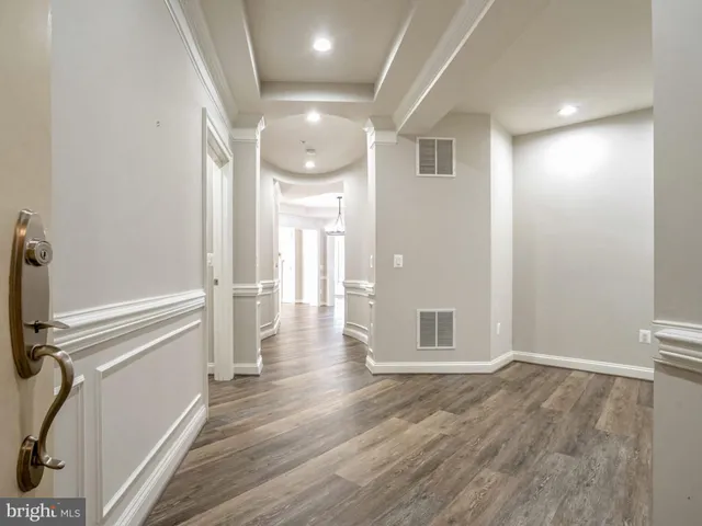 a view of a hallway with wooden floor and staircase