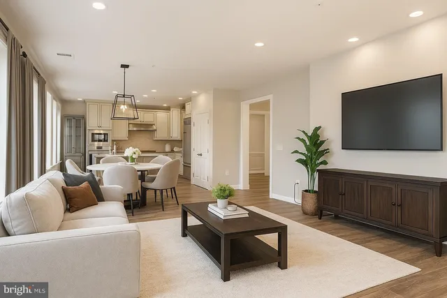 a living room with furniture kitchen view and a flat screen tv
