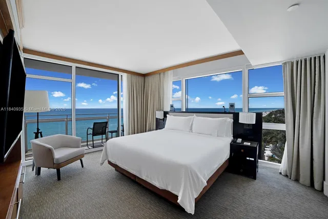 a large bedroom with a bed and large windows