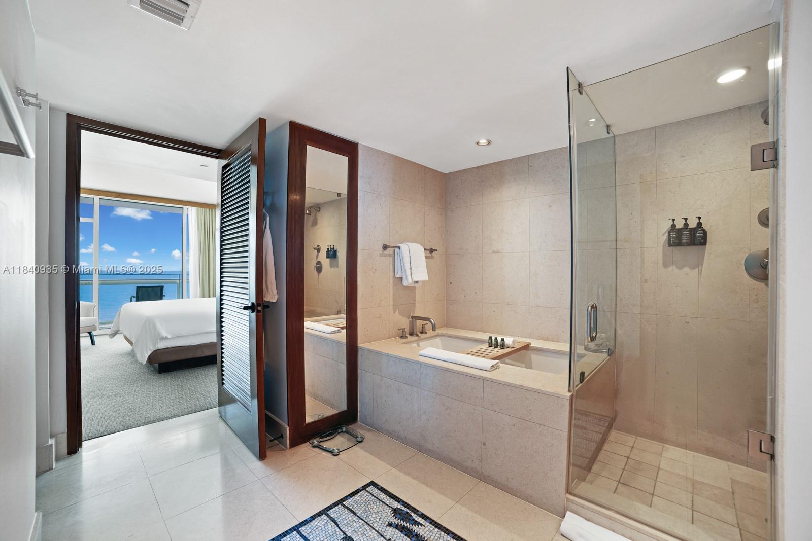 6801 Collins Avenue, Unit 705 Miami Beach, FL 33141 - Photo 14 of 54 a en suite spacious bathroom with a tub shower and bedroom view