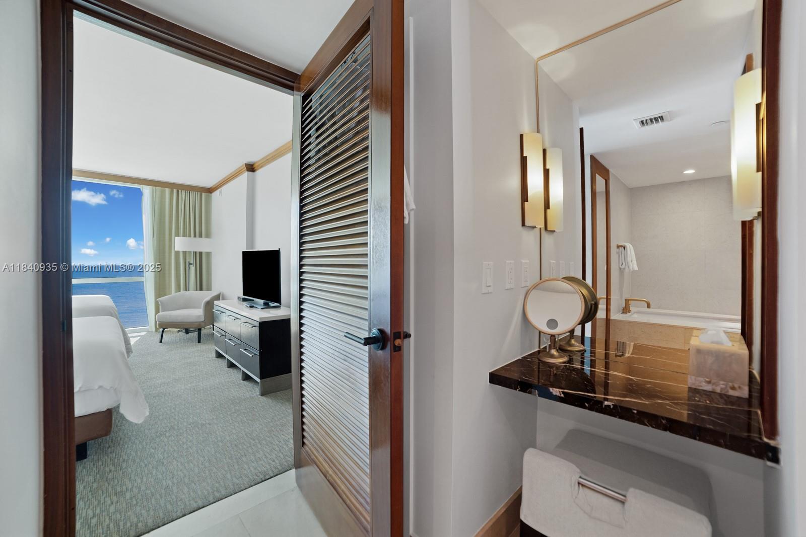 6801 Collins Avenue, Unit 705 Miami Beach, FL 33141 - Photo 15 of 54 a bathroom with a toilet a sink and mirror