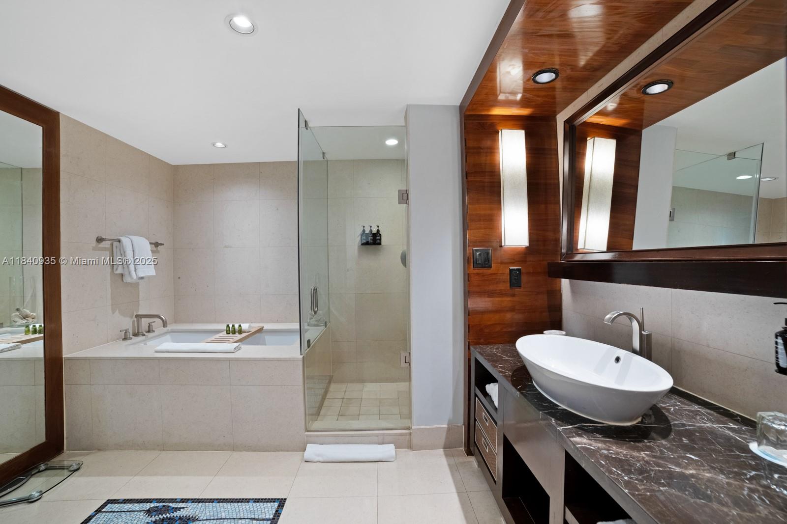 6801 Collins Avenue, Unit 705 Miami Beach, FL 33141 - Photo 20 of 54 a bathroom with a granite countertop sink a toilet a mirror and shower