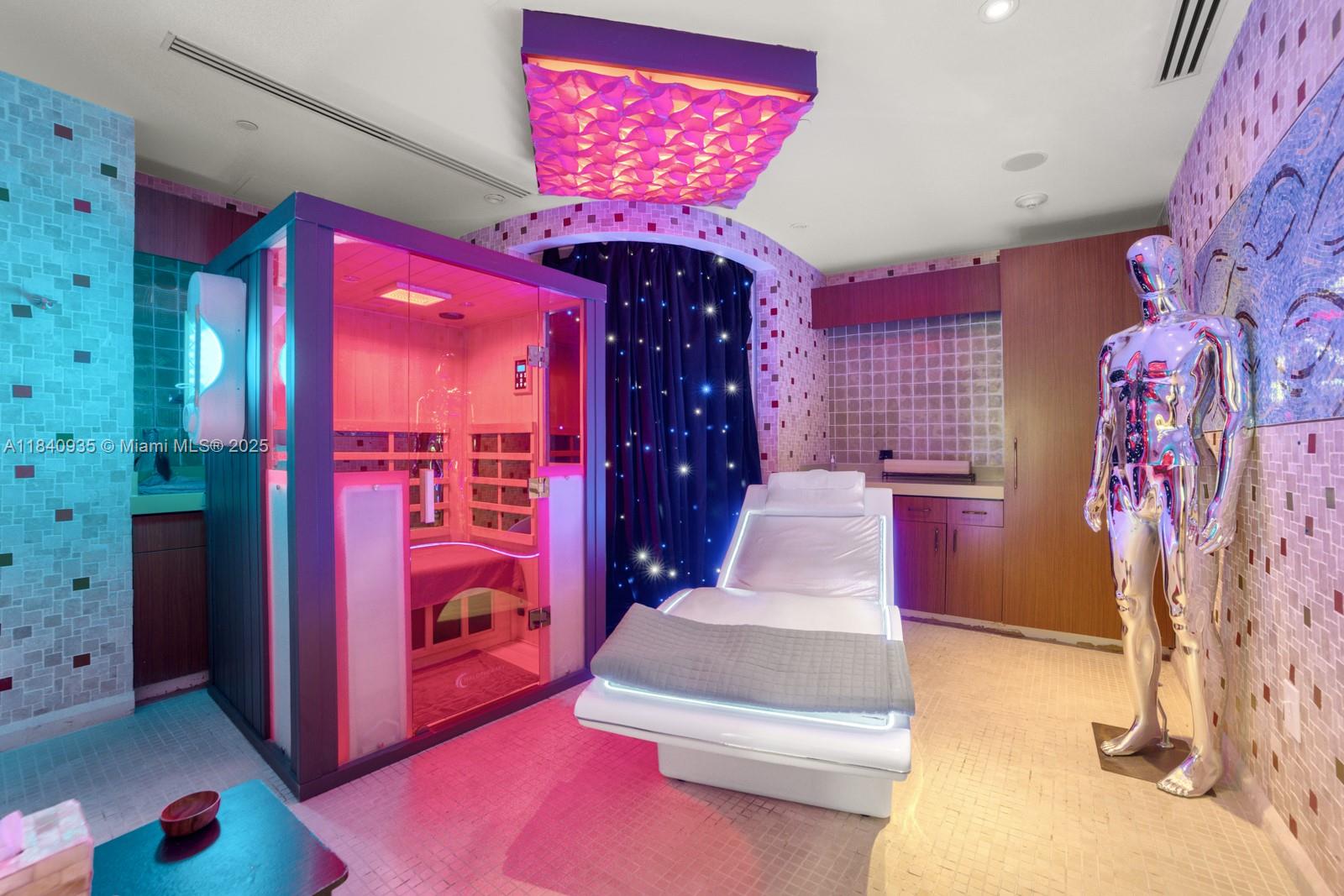 6801 Collins Avenue, Unit 705 Miami Beach, FL 33141 - Photo 38 of 54 a spacious bedroom with a bed and a chandelier