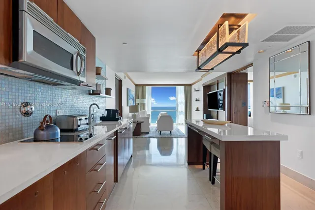 a kitchen with stainless steel appliances a sink dishwasher stove refrigerator and cabinets