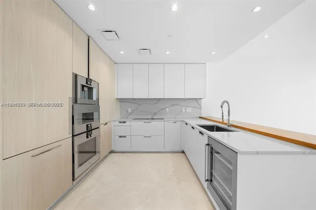 a kitchen with granite countertop cabinets appliances and a counter space