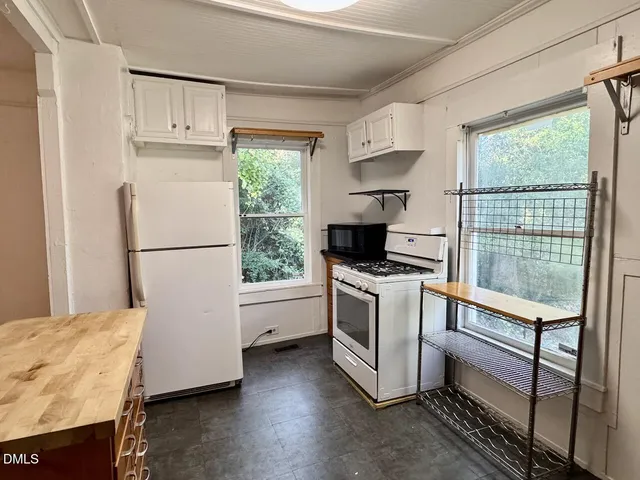 a kitchen with granite countertop a stove a sink and a refrigerator