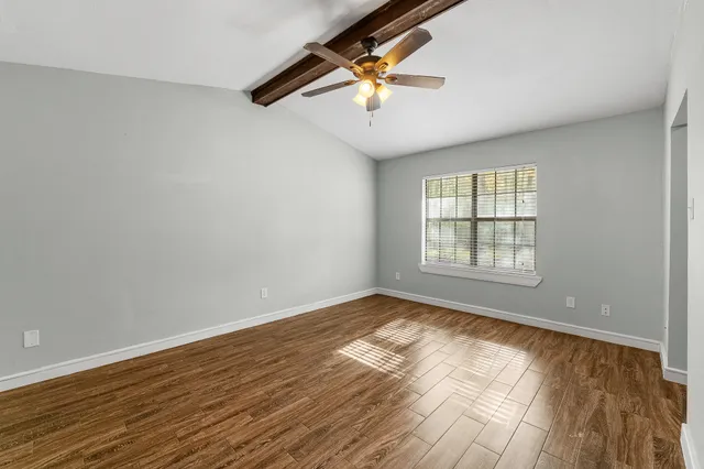 wooden floor in an empty room with a window