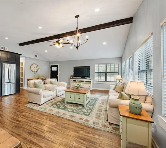a living room with furniture flat screen tv and a large window