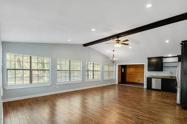 an empty room with wooden floor and fireplace