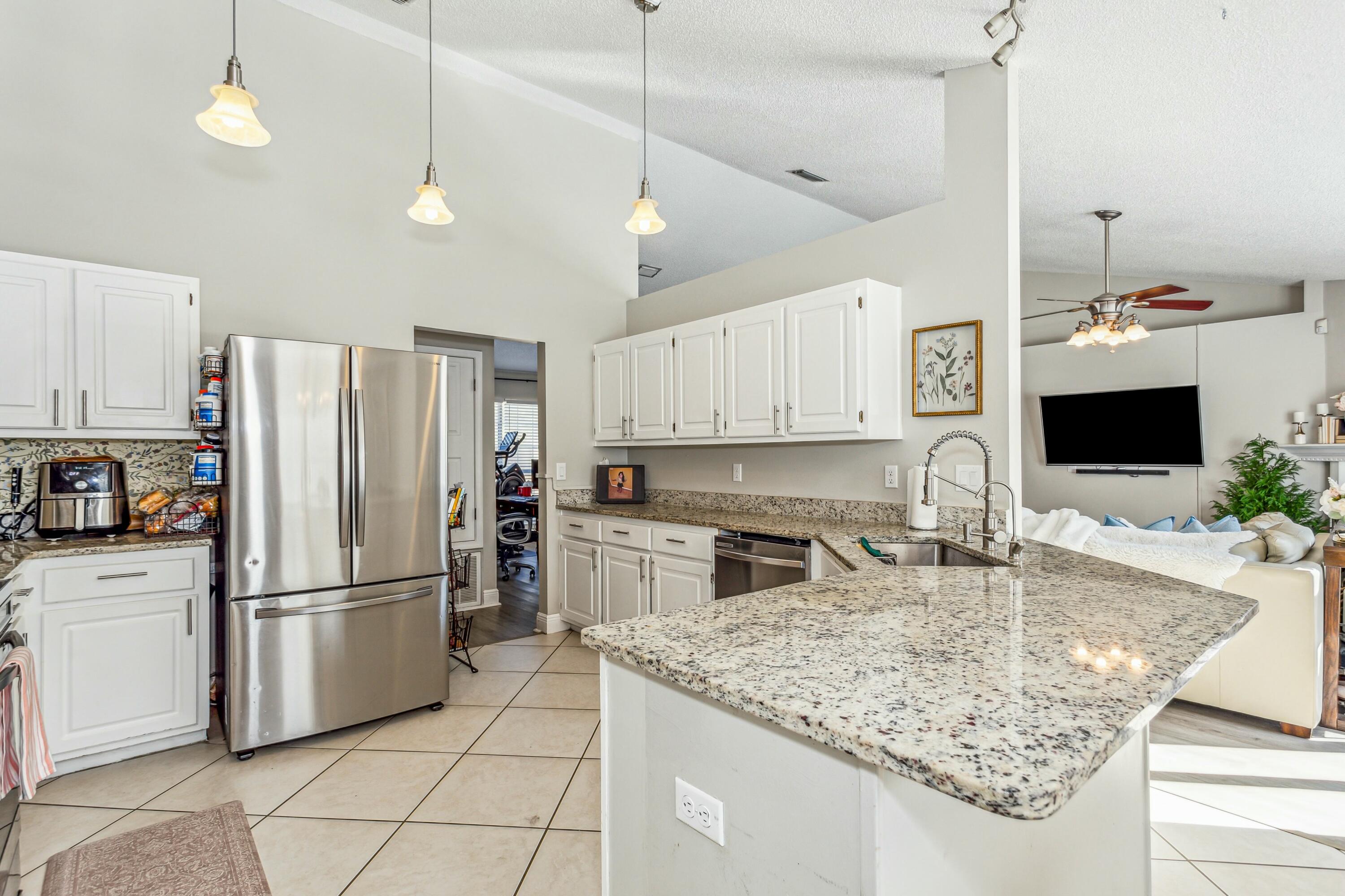 4741 Coronado Circle Crestview, FL 32539 - Photo 13 of 35 a kitchen with kitchen island granite countertop a sink appliances and cabinets