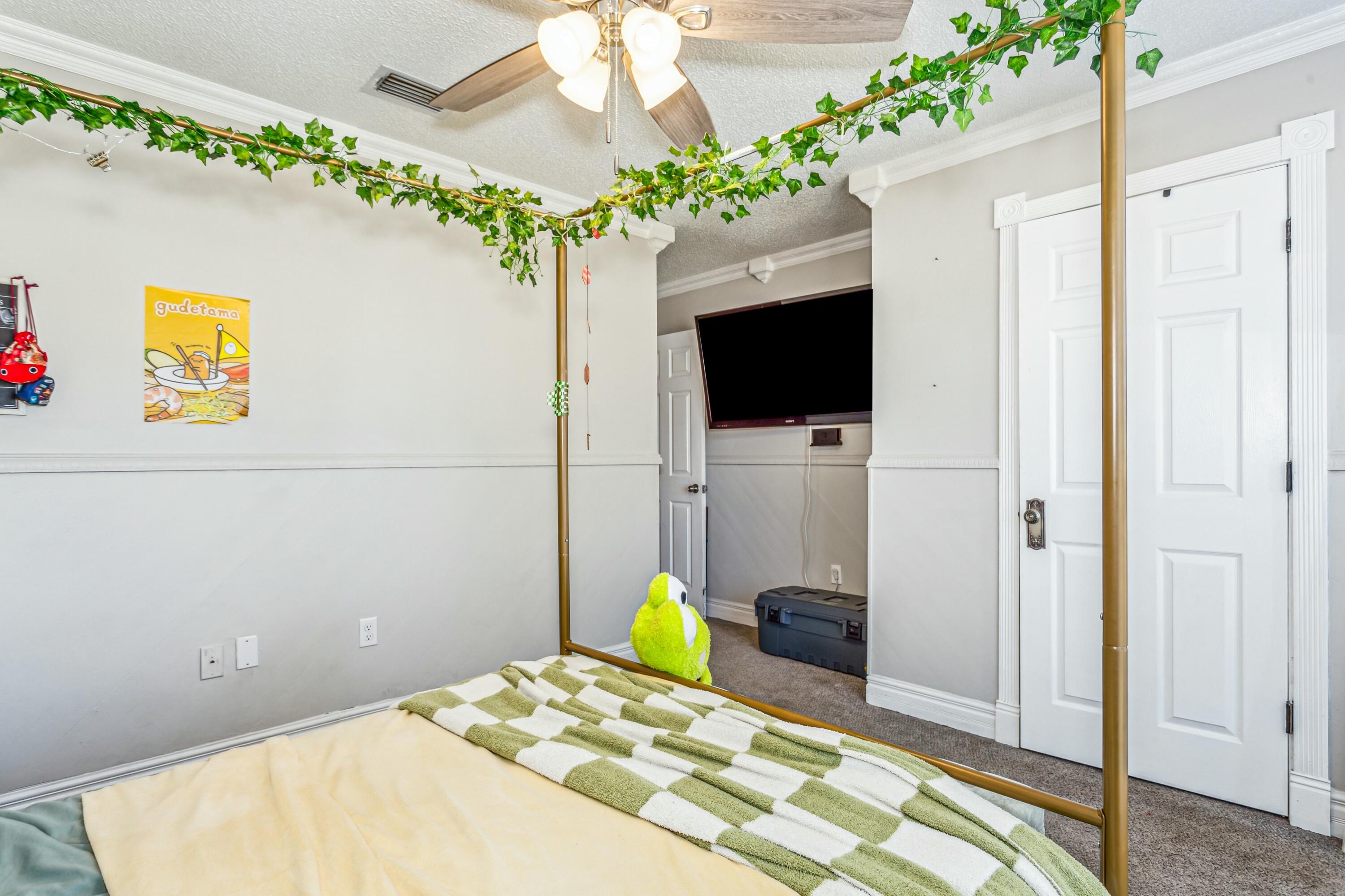 4741 Coronado Circle Crestview, FL 32539 - Photo 23 of 35 a bedroom with a bed a potted plant on the dresser and a chandelier