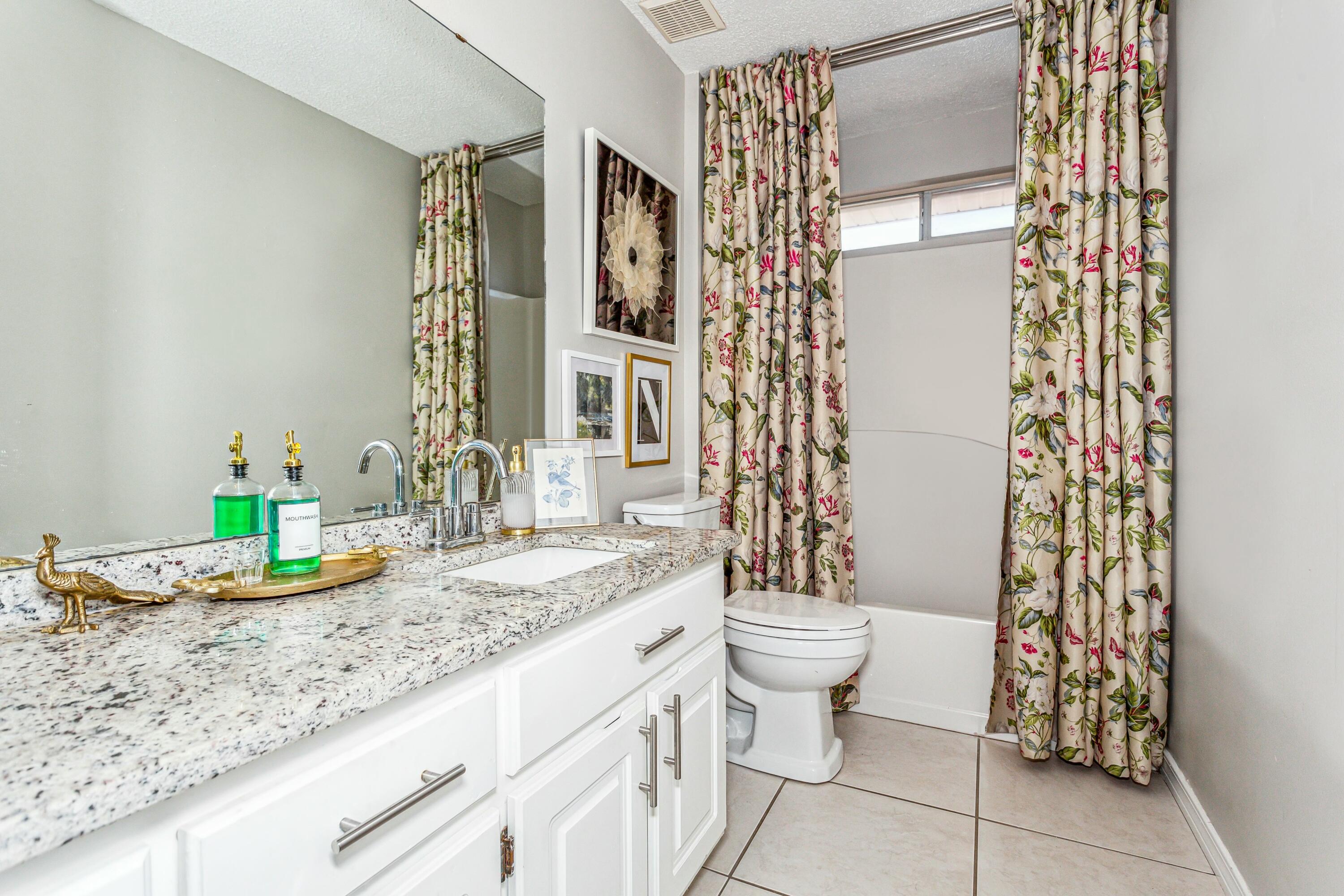 4741 Coronado Circle Crestview, FL 32539 - Photo 24 of 35 a bathroom with a granite countertop sink a toilet and a mirror