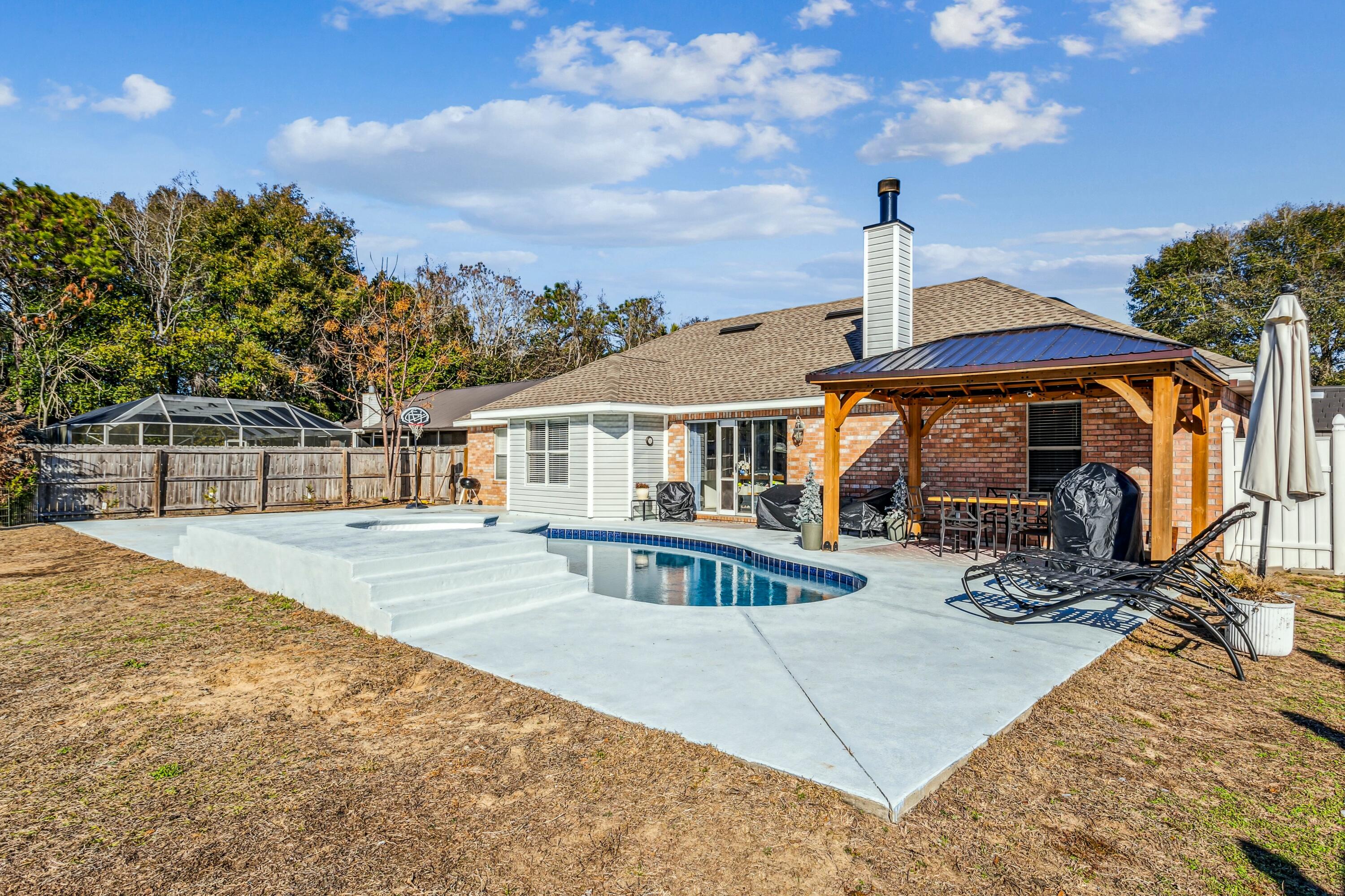 4741 Coronado Circle Crestview, FL 32539 - Photo 28 of 35 a view of a house with floor to ceiling windows and a patio
