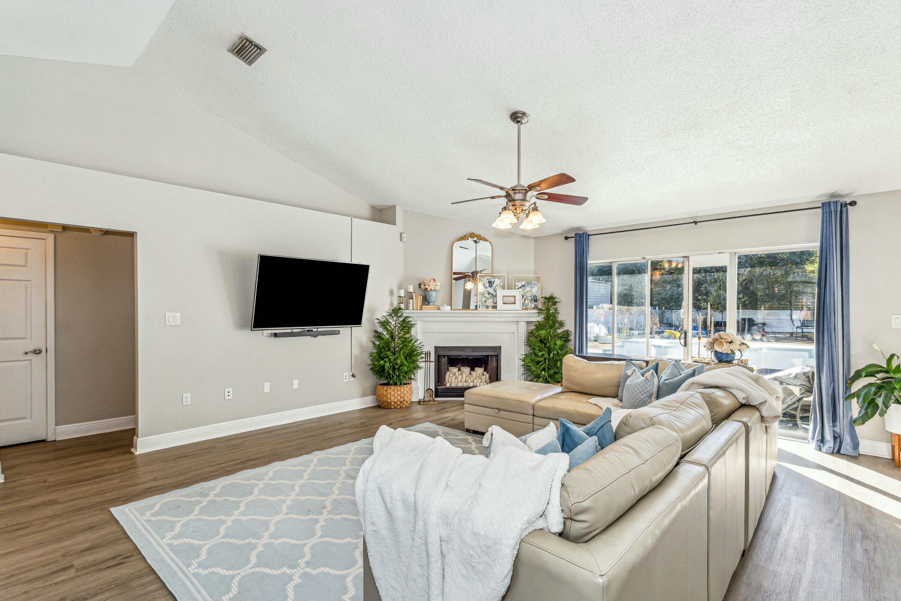 4741 Coronado Circle Crestview, FL 32539 - Photo 8 of 35 a living room with furniture a fireplace and a flat screen tv