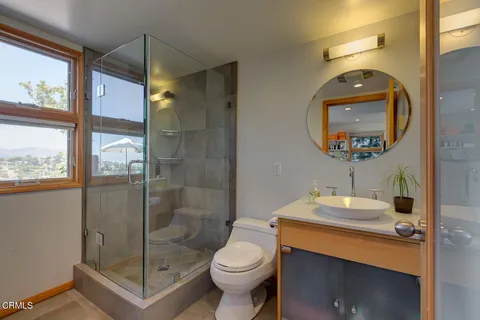 a bathroom with a toilet a sink and glass door