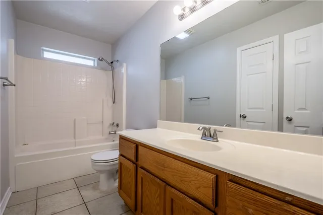 an empty room with windows and chandelier fan