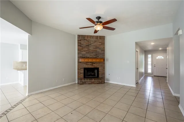 a view of an empty room with exposed radiator and fireplace