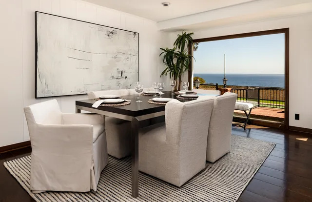 a dining room with furniture and a potted plant