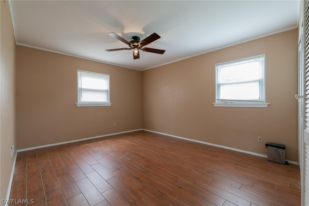 1612 Coronado Road Fort Myers, FL 33901 - Photo 6 of 26 a view of empty room with wooden floor and fan