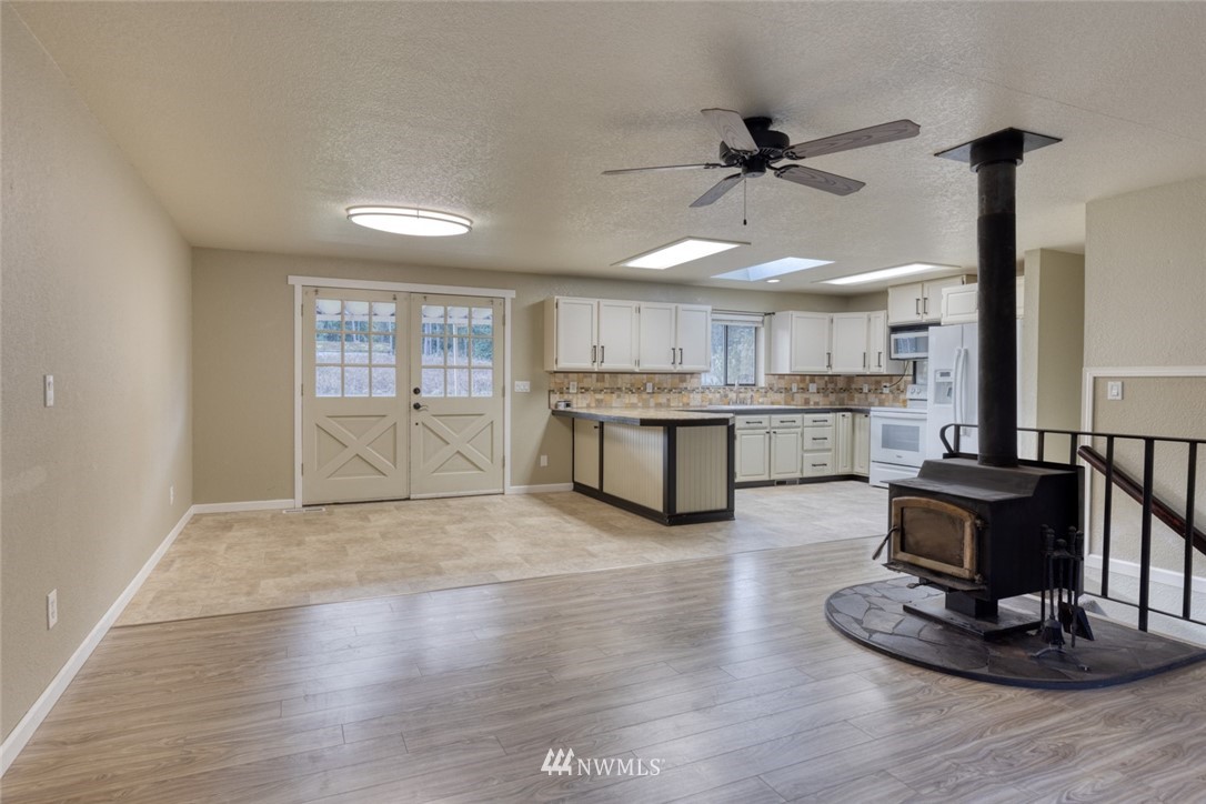17517 48th Street East Lake Tapps, WA 98391 - Photo 5 of 36 a living room with stainless steel appliances kitchen island granite countertop furniture and a fireplace