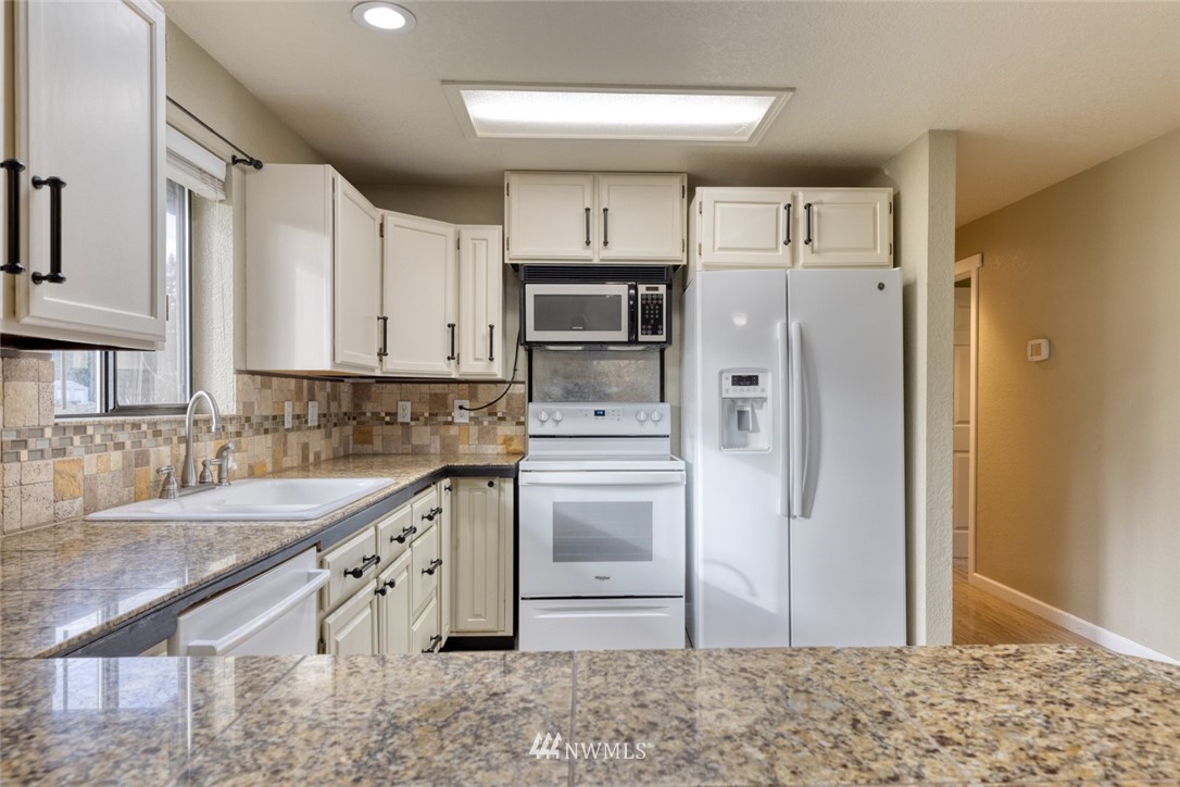 17517 48th Street East Lake Tapps, WA 98391 - Photo 9 of 36 a kitchen with stainless steel appliances granite countertop a refrigerator a stove and a sink