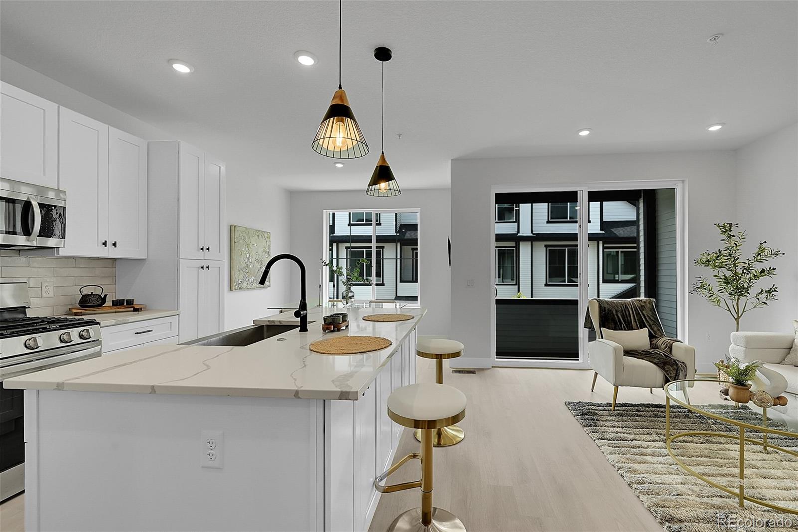8530 West 52nd Avenue, Unit E3 Arvada, CO 80002 - Photo 16 of 27 a kitchen with stainless steel appliances kitchen island granite countertop a sink and a stove top oven