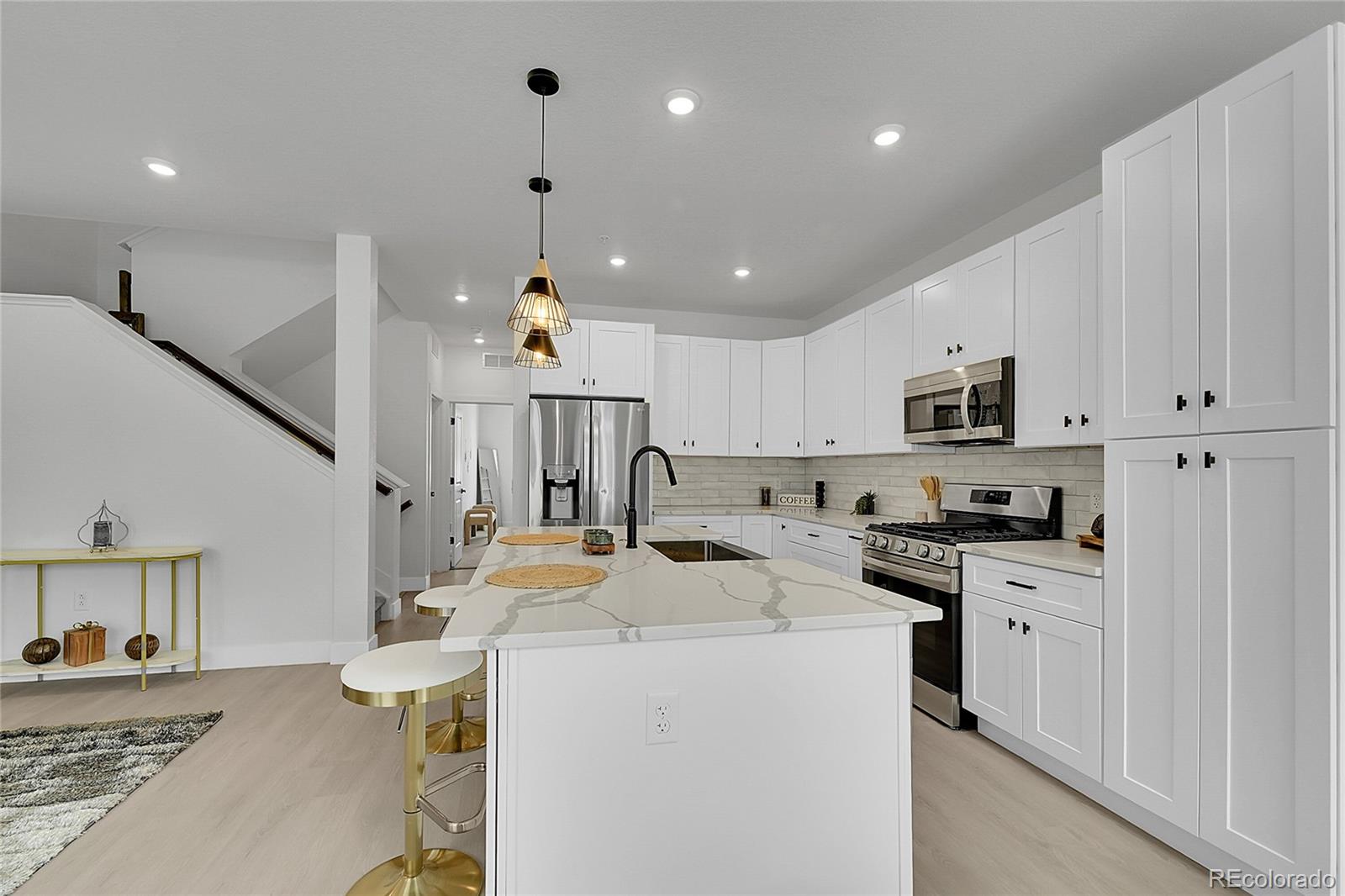 8530 West 52nd Avenue, Unit E3 Arvada, CO 80002 - Photo 17 of 27 a kitchen with stainless steel appliances kitchen island a stove a sink a refrigerator and cabinets