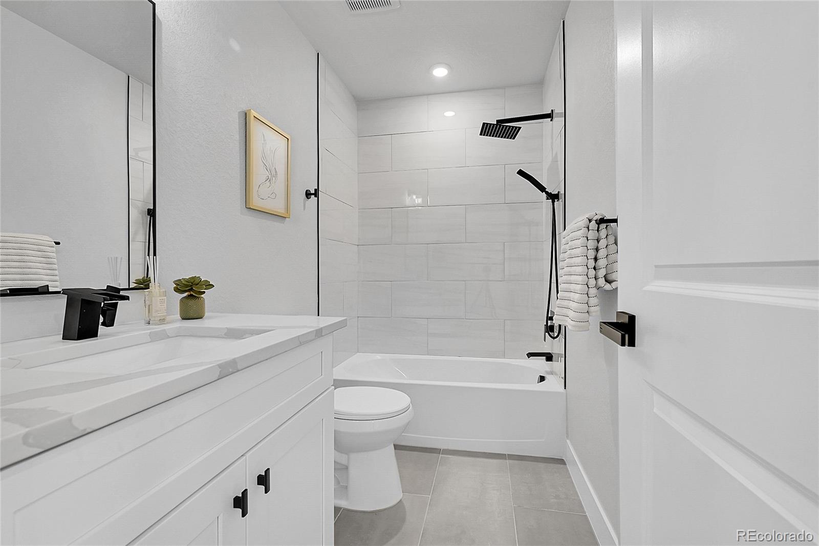 8530 West 52nd Avenue, Unit E3 Arvada, CO 80002 - Photo 24 of 27 a bathroom with a bathtub shower sink vanity and a toilet