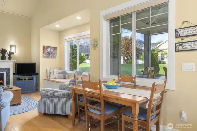 a dining room with furniture a large window and a flat screen tv